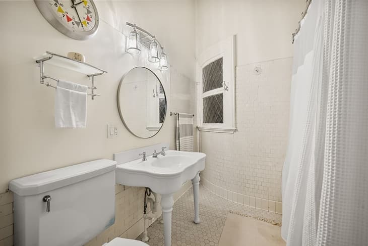 White tiled bathroom in Boston studio apartment.