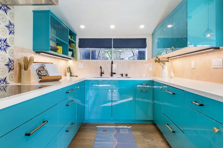 kitchen with bright turquoise cabinets and blue and white patterned wallpaper accents