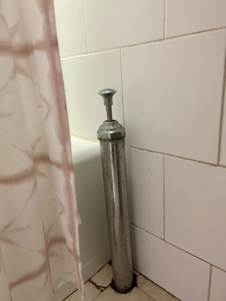 Drain lever in white bathroom.