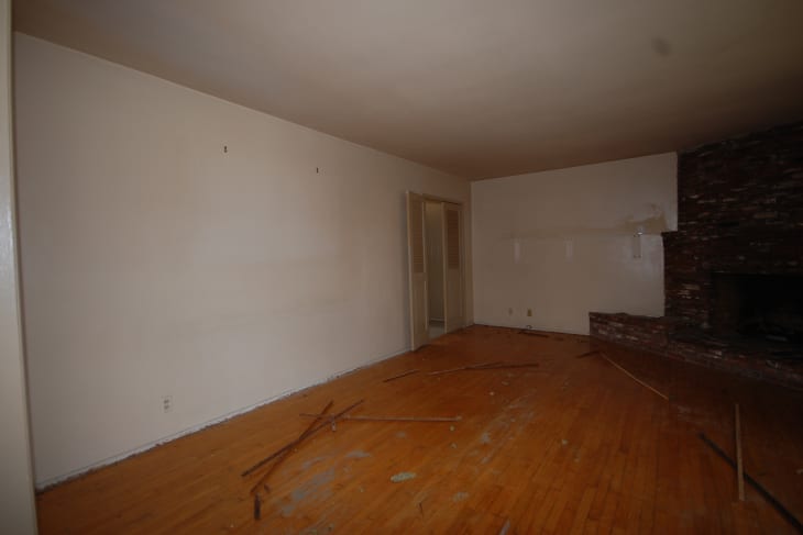 Empty living room with brick fireplace before home staging