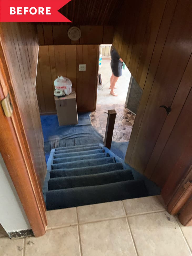 Before: Stairs leading to dated '70s basement with blue carpet