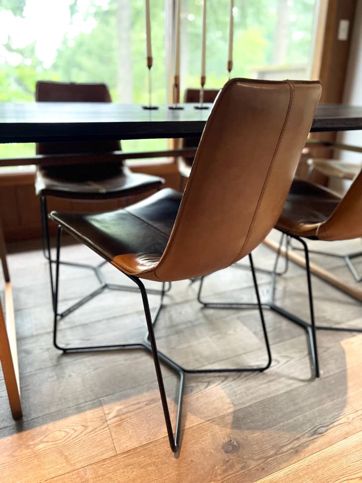 Brown leather West Elm chairs under dining table.