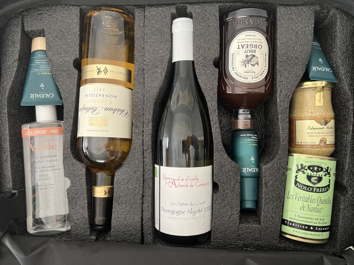 Wine, spreads, and beauty products in a suitcase