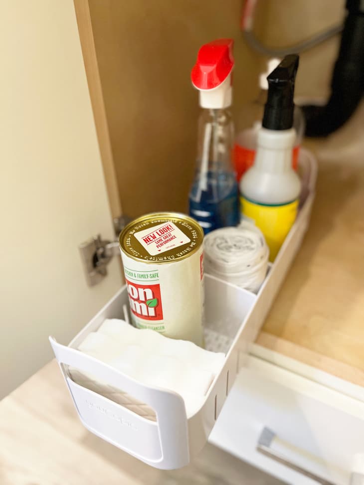 rolling caddy under the sink with cleaning supplies organized in compartments