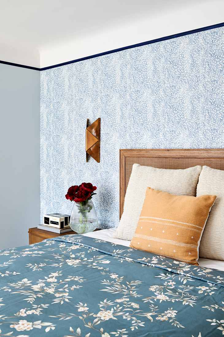 Blue and gray bedroom with black "trim" and one patterned wallpaper wall