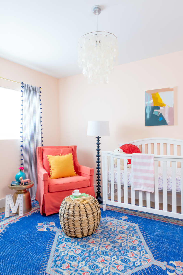 Nursery with blush walls and a blue carpet