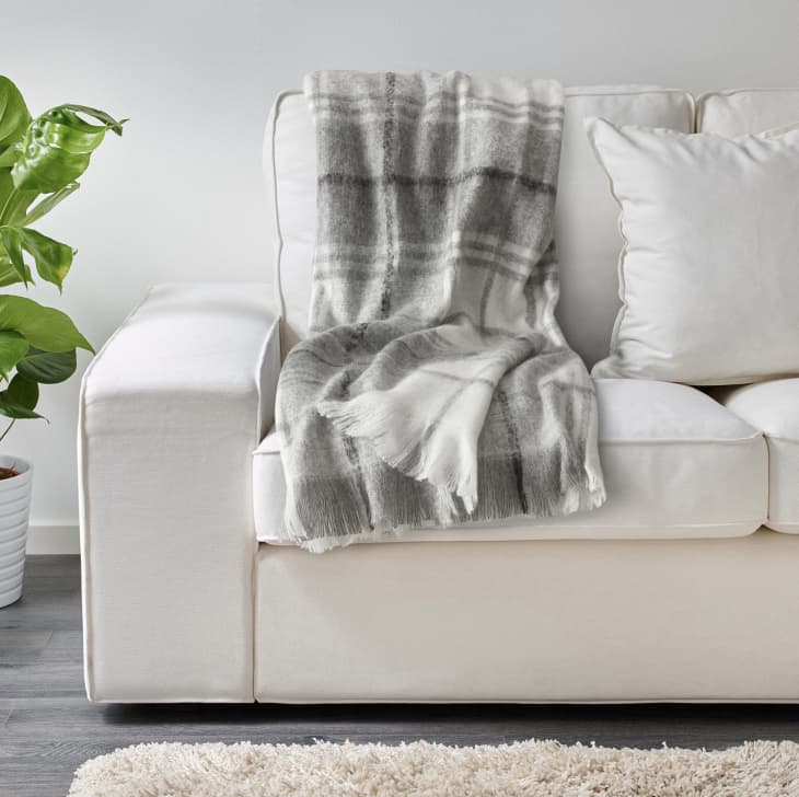Neutral plaid throw blanket on off-white sofa