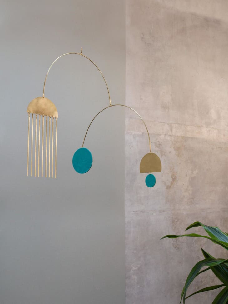 Hanging metal artwork with turquoise and gold circles and half circles
