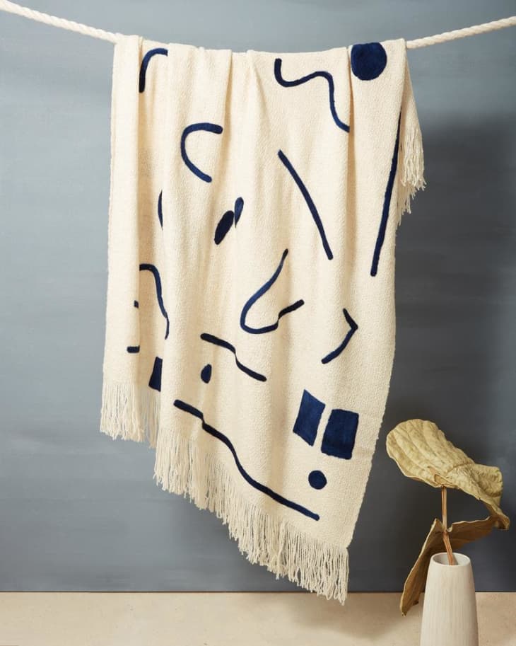 Cream throw blanket with abstract indigo shapes on it