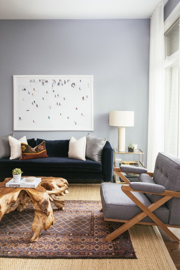 Bright living room with gray walls, gray chair and blue velvet sofa