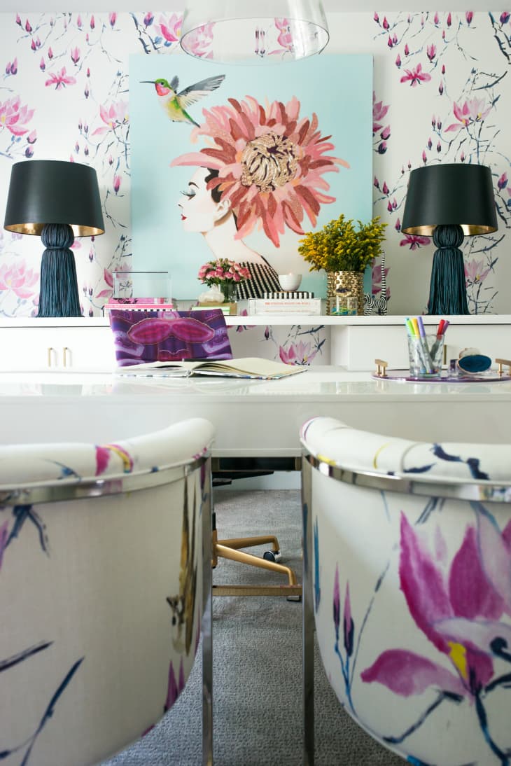 Office space with floral wallpaper, wall art, and chairs