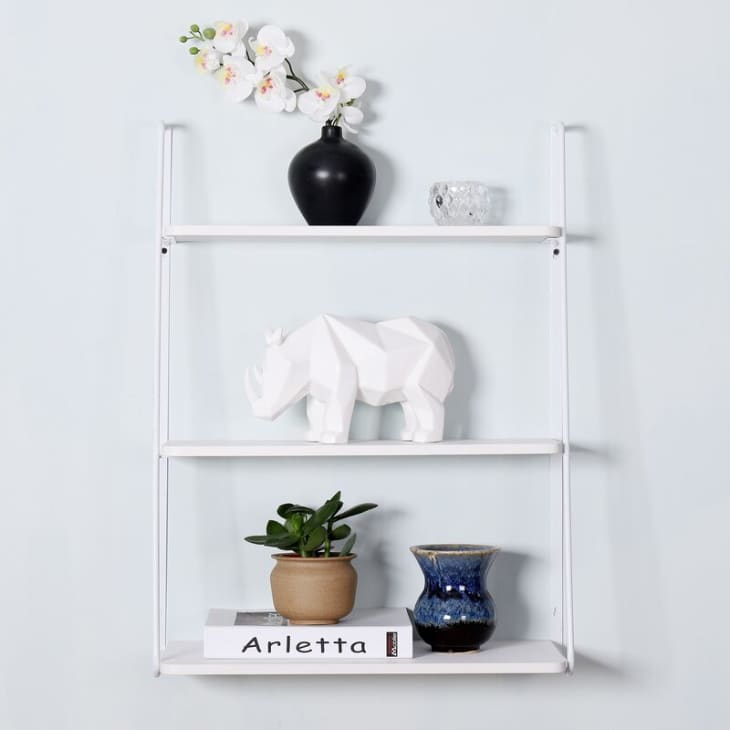 White metal wall mounted shelf with three tiers
