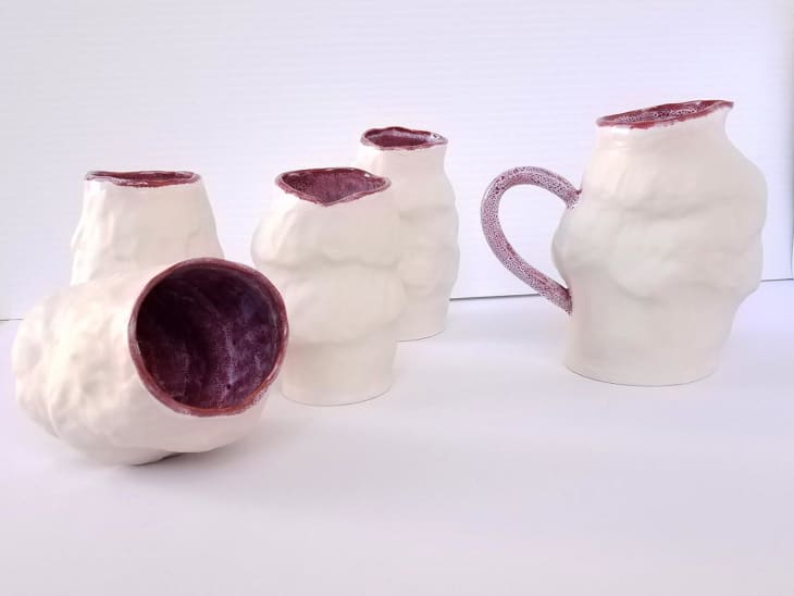Lumpy off-white pottery with brick red interior
