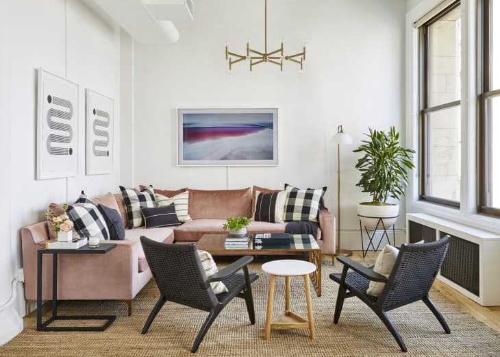 Living room with a pink sectional and black accent chairs