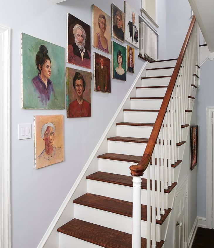 White stairwell with painted portraits