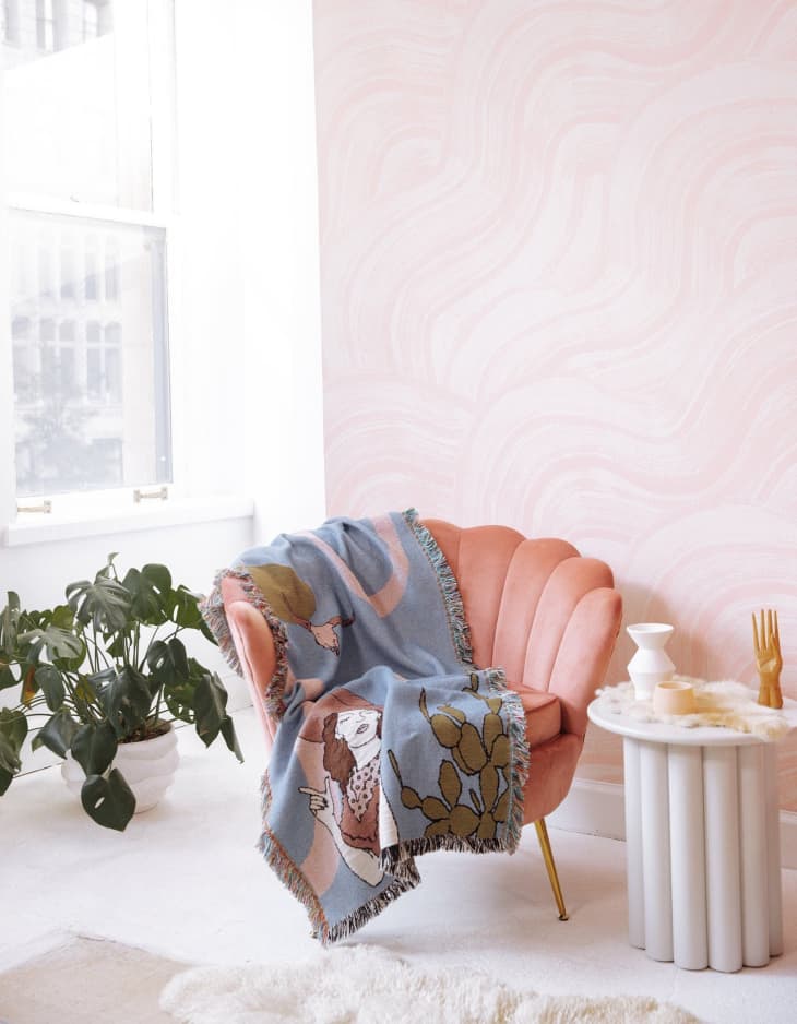 pink chair with decorative woven throw blanket