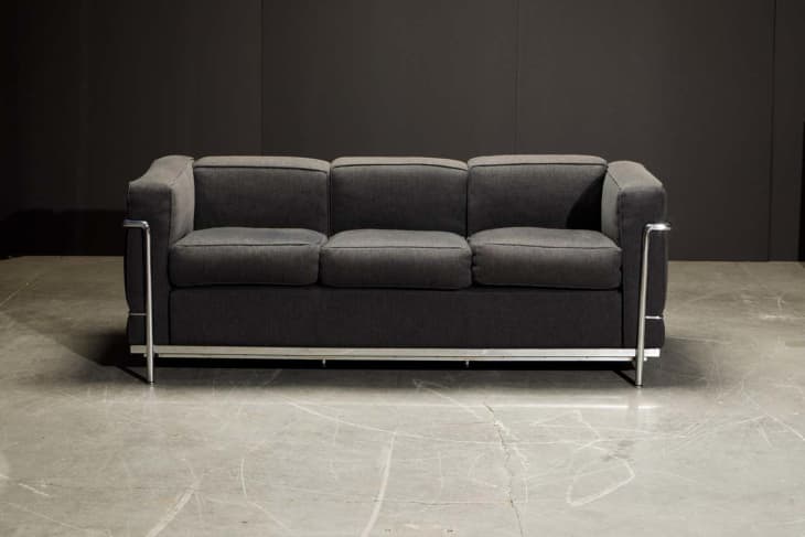 LC2 Sofa with black leather cushions and a stainless steel frame