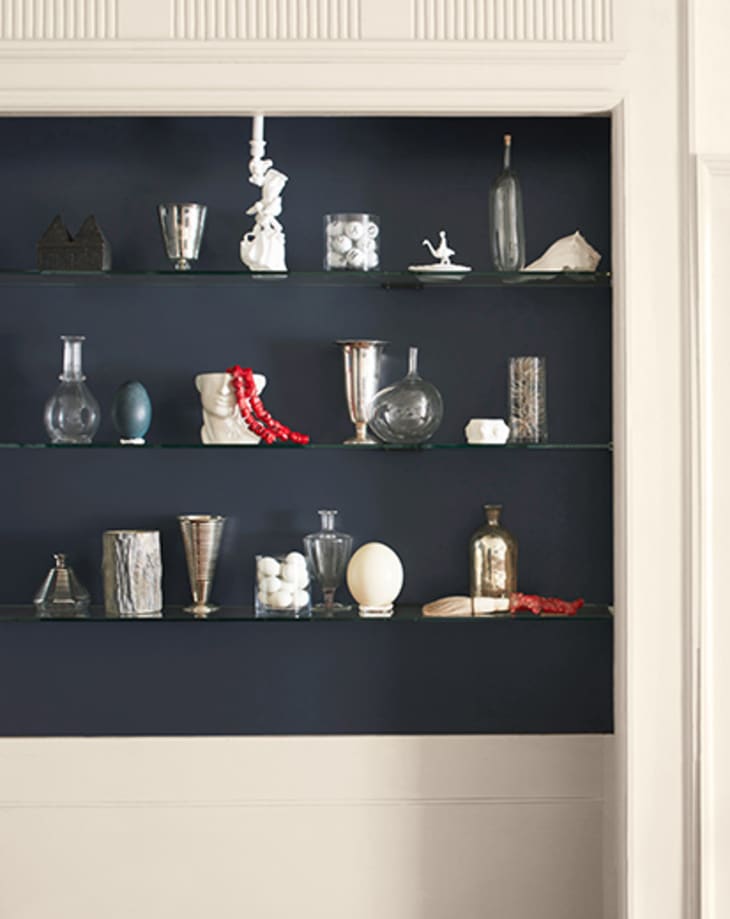 Benjamin Moore's Mysterious, a navy-ish charcoal in the 2022 color trends palette, backing a shelf of objects.