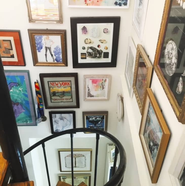 Spiral staircase with a colorful gallery wall around it in a Manhattan apartment