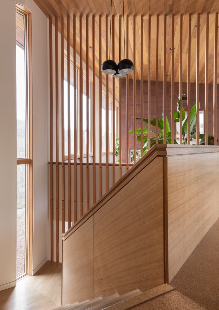Wooded slats and staircase in an entry by Guggenheim Architecture + Design Studio