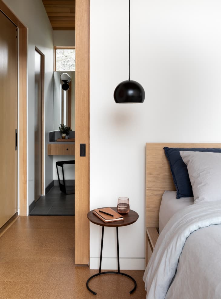 Bedroom with a hanging pendant over a nightstand designed by Guggenheim Architecture + Design Studio