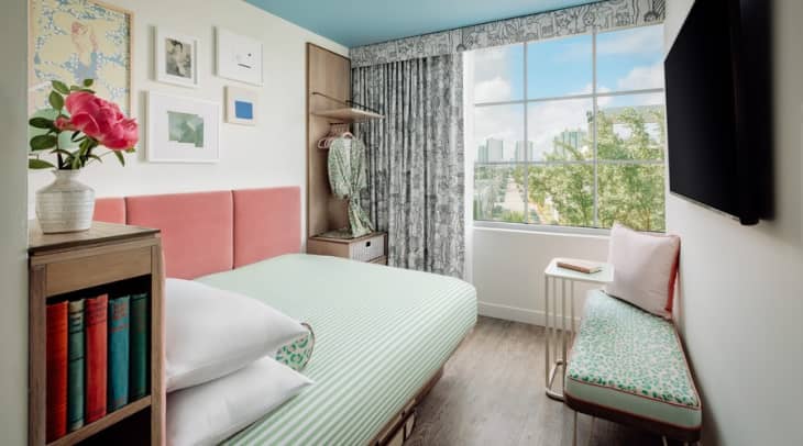 The Goodtime Hotel Room Interior with green ticking bedding and a pink headboard