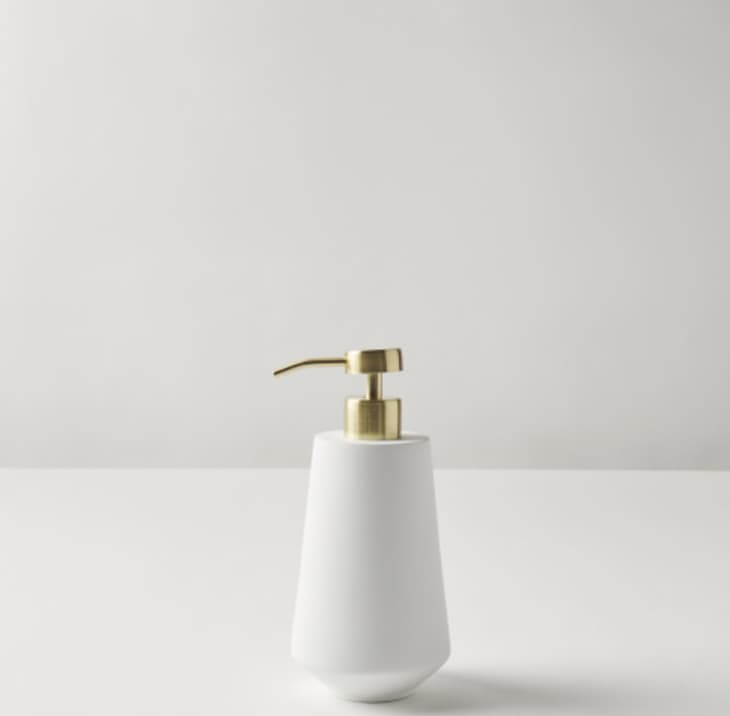 White soap dispenser with a gold top
