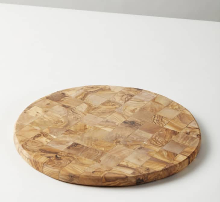 Circular cutting board made out of mosaic-look olive wood