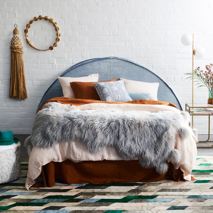 Sheepskin on a bed that's decorated boho style