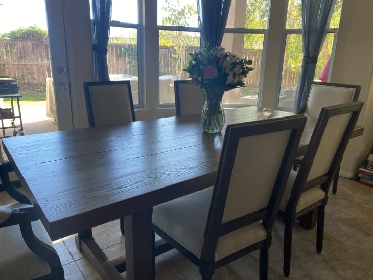 Wooden dining table with beige upholstered chairs