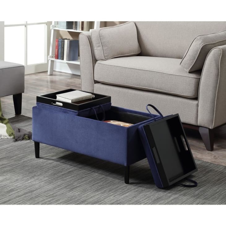 A blue ottoman open revealing storage space