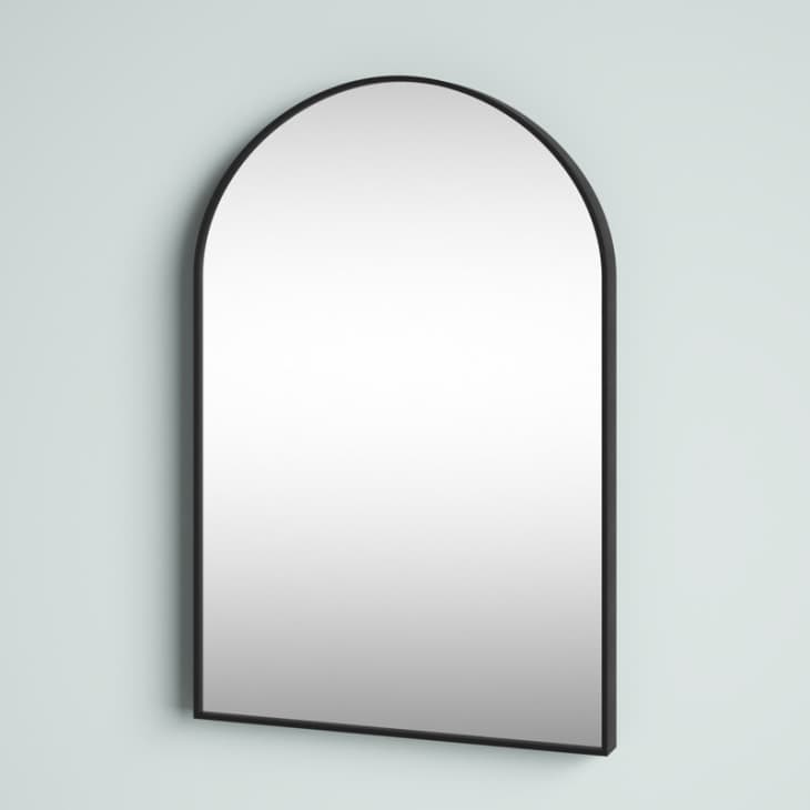 A rectangular mirror that rounds at the top