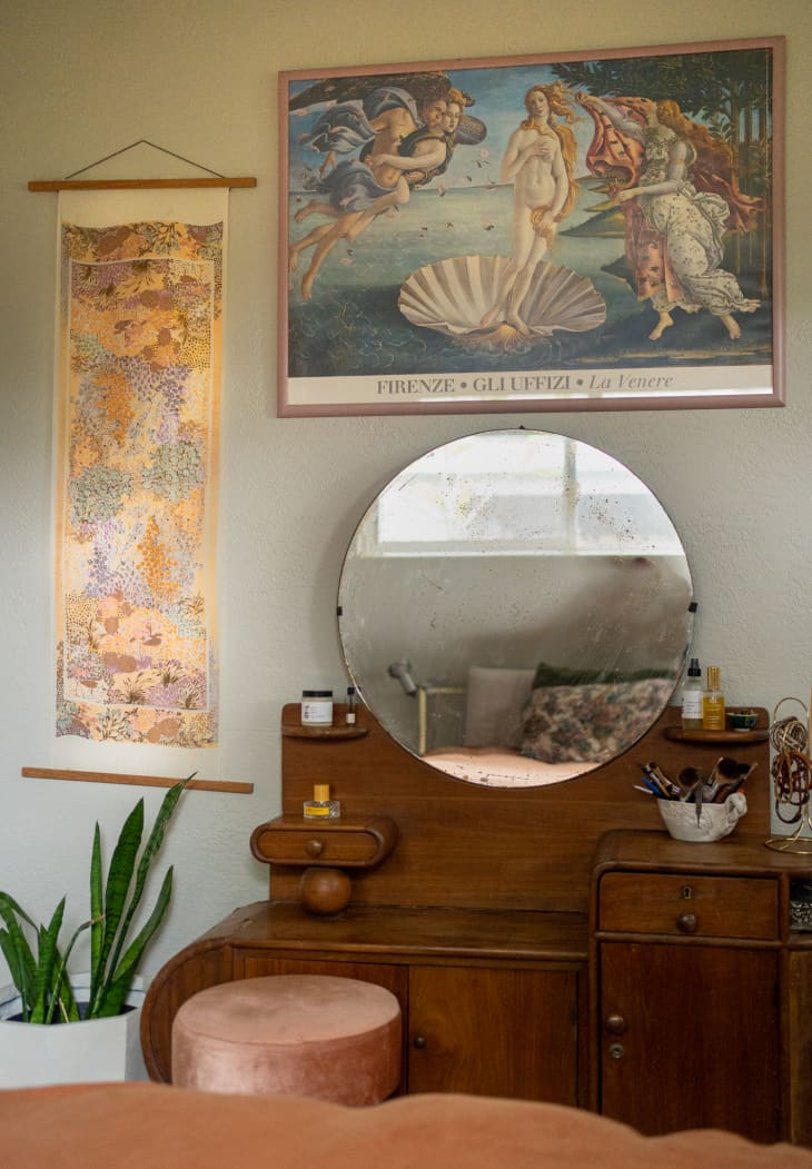 A silk scarf hanging next to a mirror and an art print