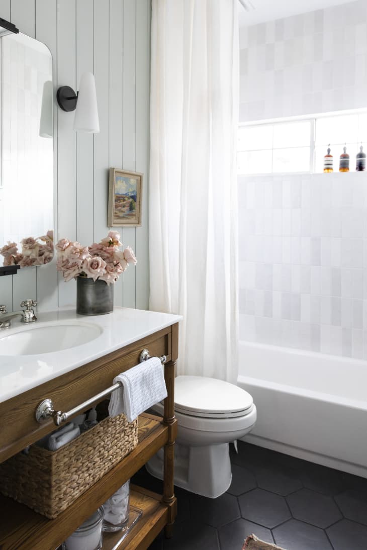 Small white bathroom with open vanity and white paneling