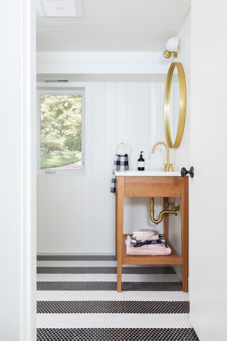 bathroom with white vertical paneling and a striped penny tile floor