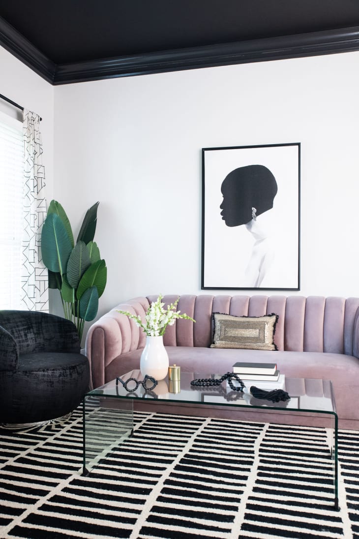"she cave" designed by Marie Cloud of Indigo Pruitt with a black ceiling and a striking silhouette art piece hung over a curved lilac channel back sofa