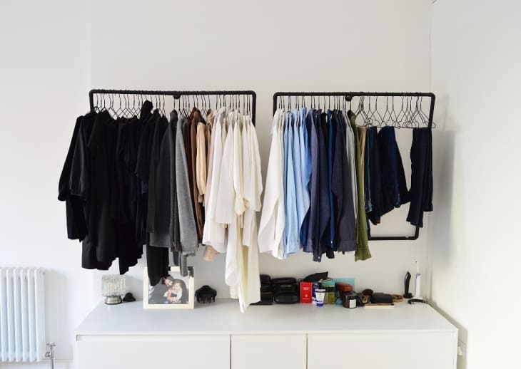 An open closet on two black frames against a white wall