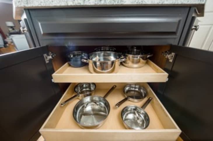 Black cabinet with pull-out inserts that make grabbing the pots and pans pictured easier
