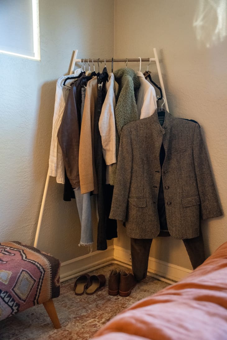 A clothing rack in the corner of a room