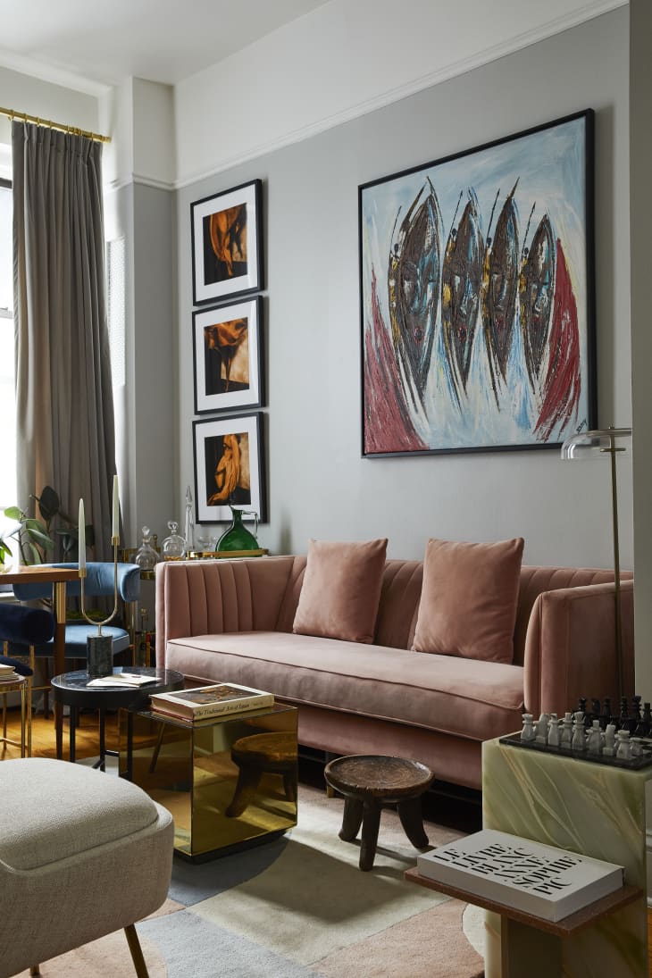 Gray living room with pink sofa and stunning artwork in blues and reds and pinks over the sofa