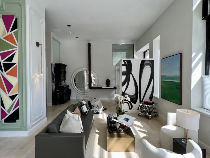Room painted in neutral pale gray with black and white accents, light wood floor