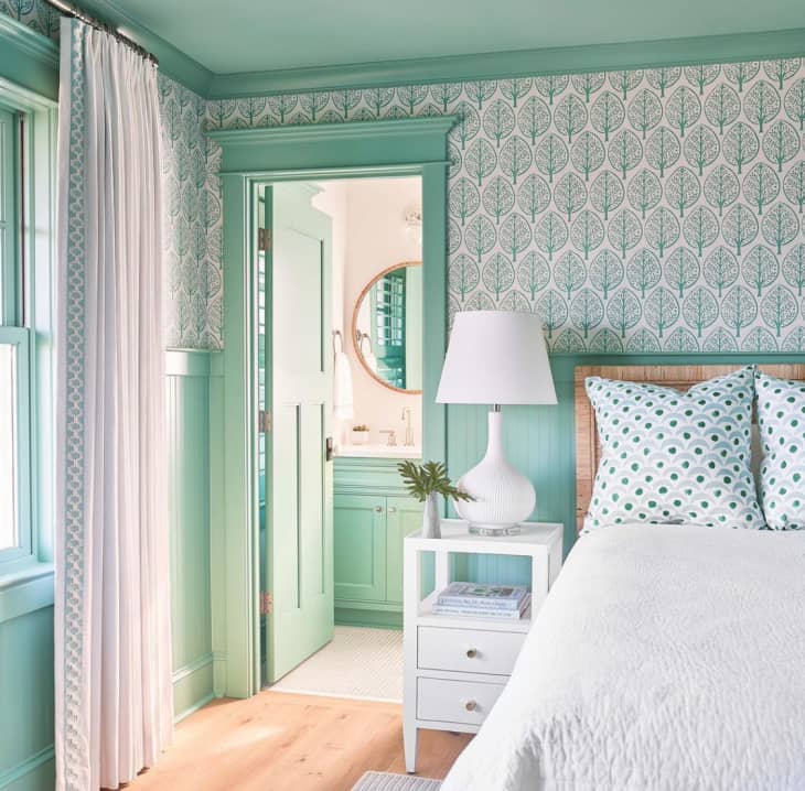 Mint green patterned wallpaper, mint painted doors, cabinets and white bed