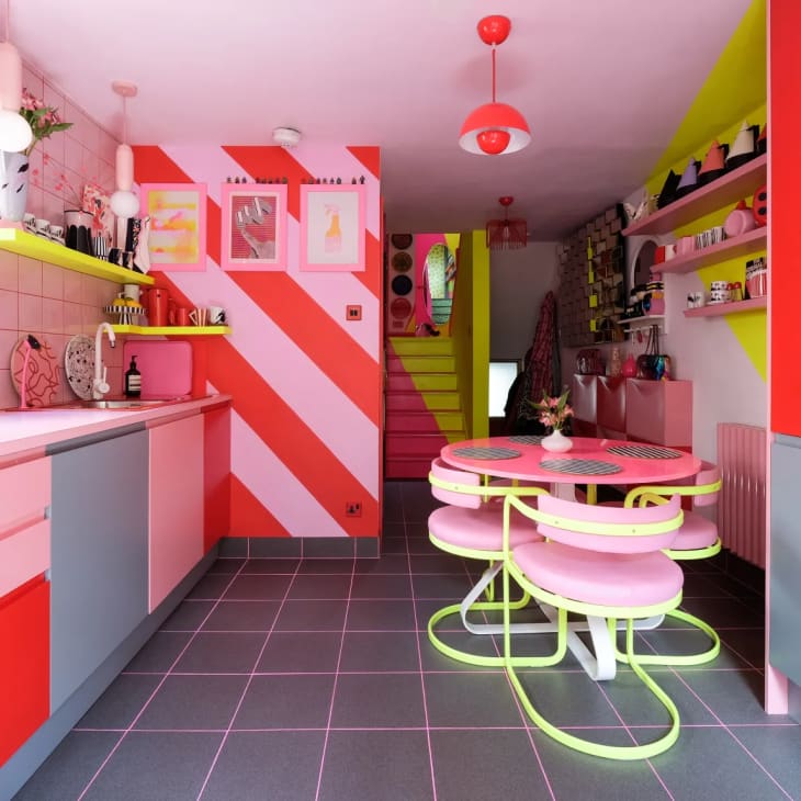 pink kitchen with vibrant pink, red, and yellow colors and a gray tile floor