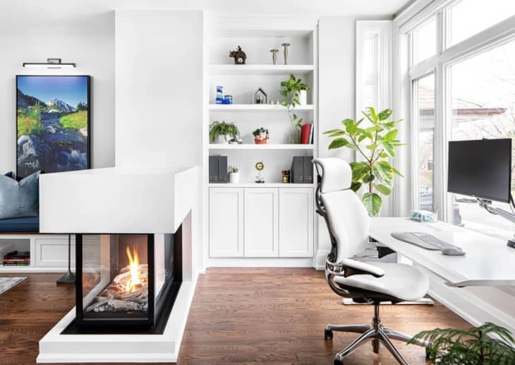 an open office divided by a modern fireplace