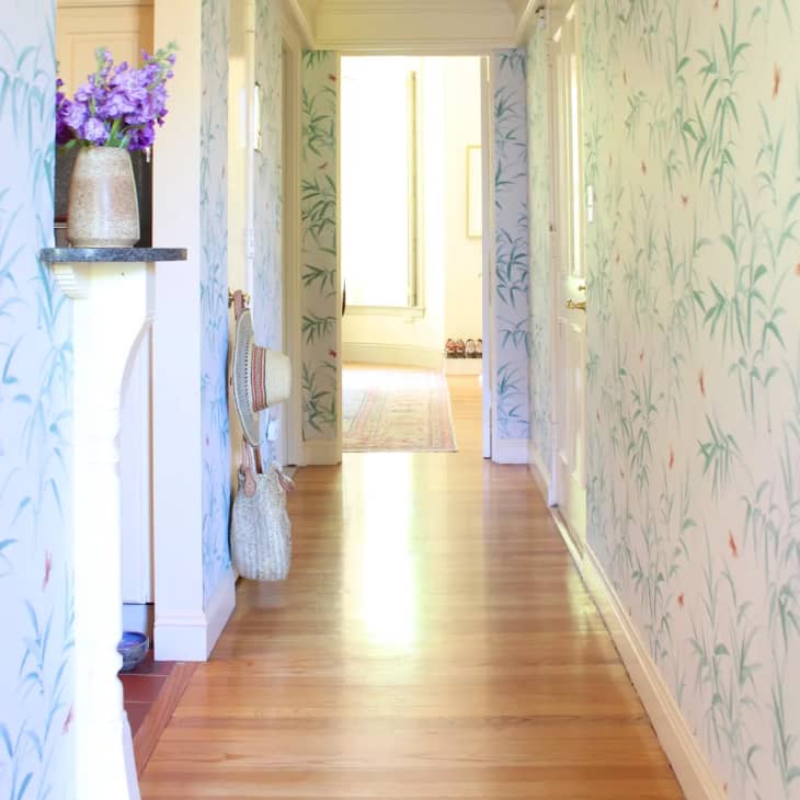 a hallway with tropical white and green wallpaper