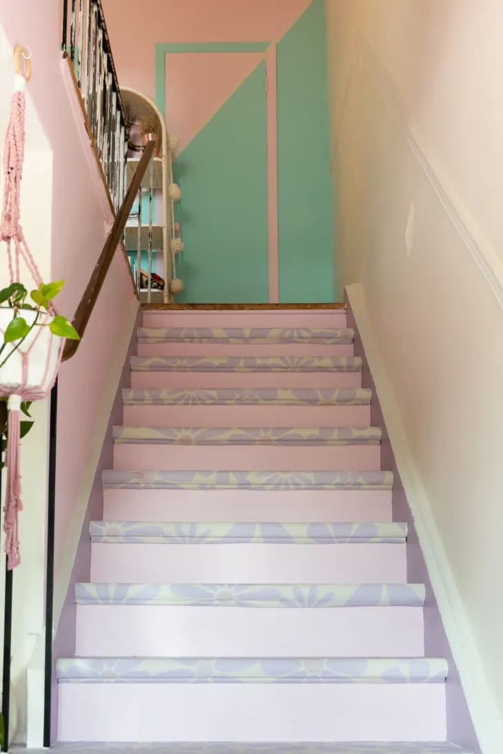 a pastel stairway with wallpapered treads