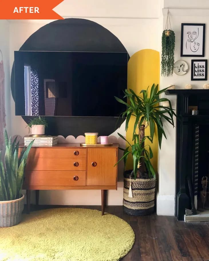 a tv mounted to the wall camouflaged by a big black dot painted on the wall