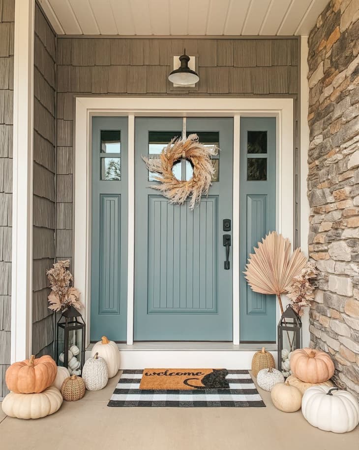 front door with different muted colored pumpkins, straw accents
