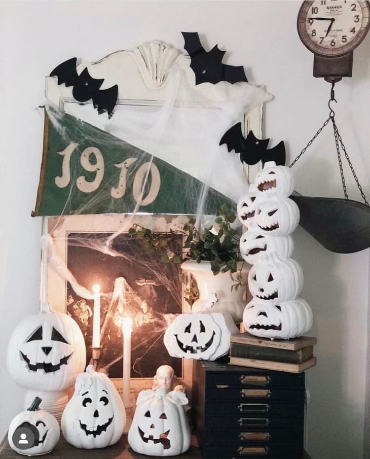 halloween display with white jack o lanterns, bats.cobwebs