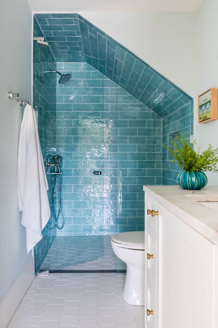 绿松石蓝色瓷砖淋浴,我走n shower, angled ceiling, tile on shower ceiling, glass door, white tile on floor, white vanity, white toilet, plant, towel bar